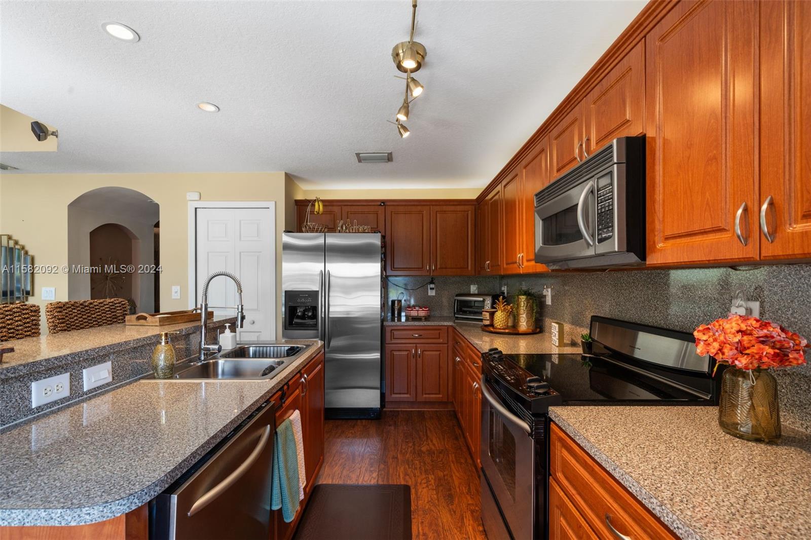 3091 Southwest 153rd Path Miami, FL 33185 - Photo 12 of 34 a kitchen with stainless steel appliances granite countertop a sink a stove top oven and cabinetry