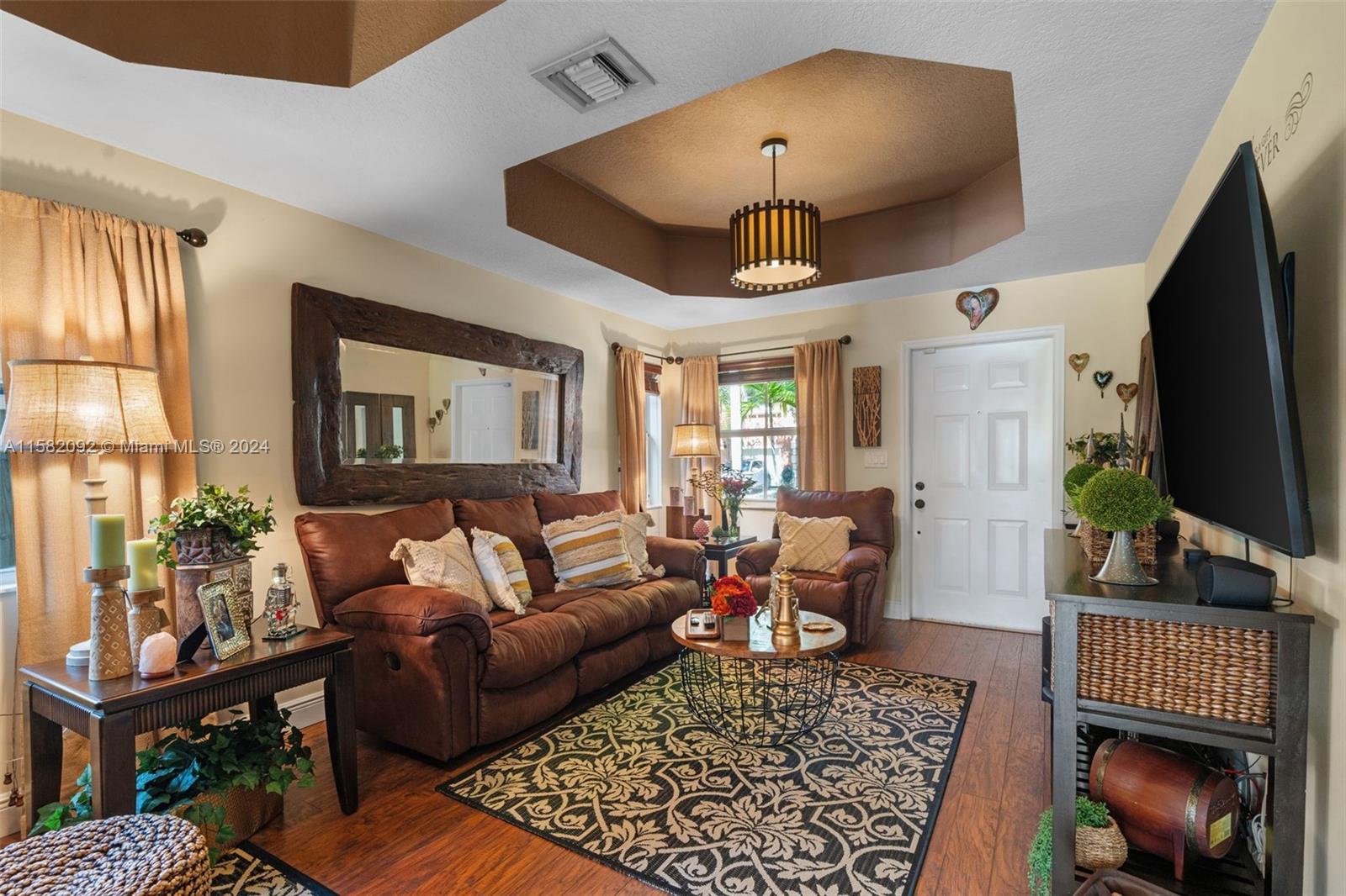 3091 Southwest 153rd Path Miami, FL 33185 - Photo 5 of 34 a living room with furniture a chandelier and a flat screen tv