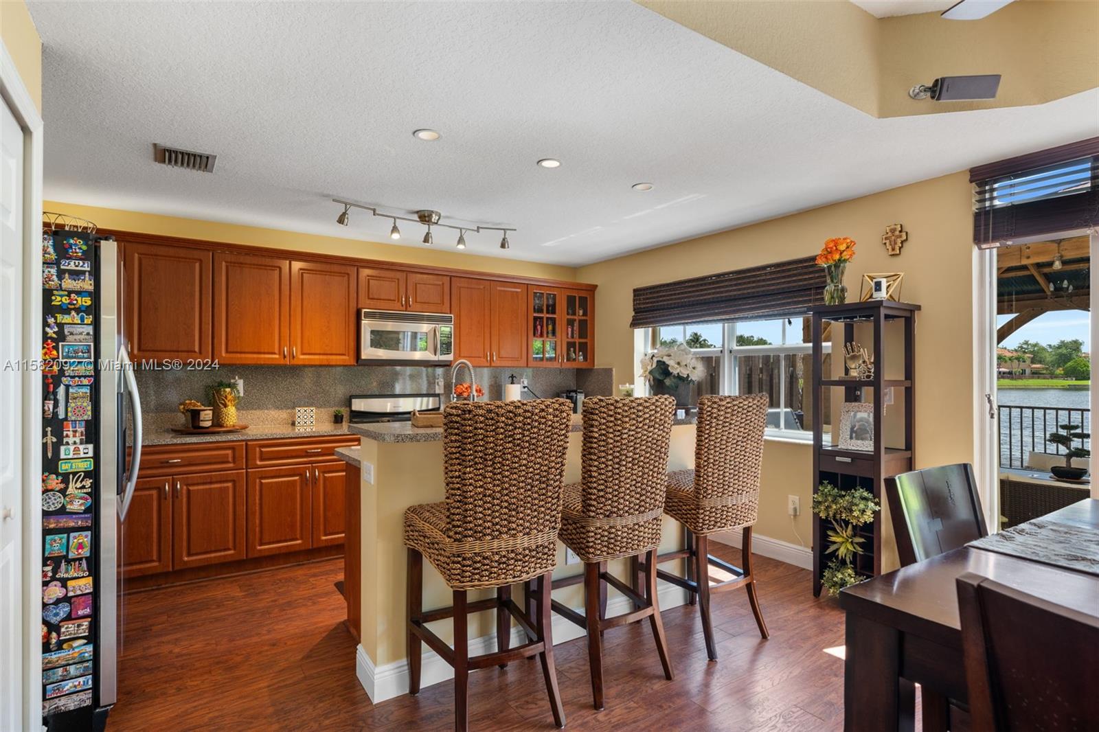 3091 Southwest 153rd Path Miami, FL 33185 - Photo 10 of 34 a dining room with stainless steel appliances granite countertop a refrigerator a stove top oven a dining table and chairs with wooden floor