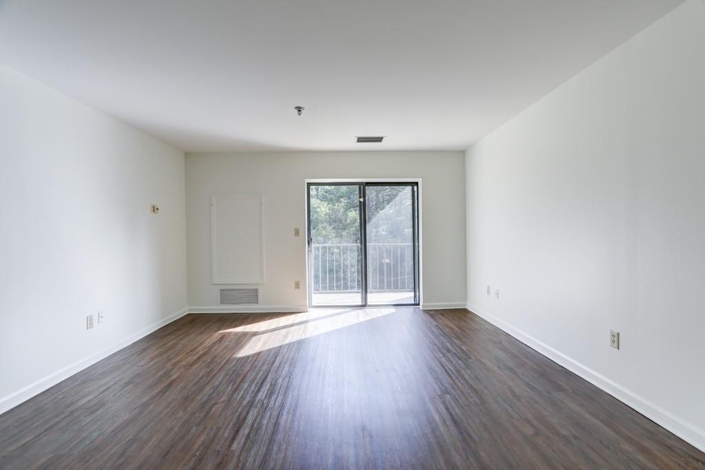 300 Johnson Ferry Road, Unit A405 Atlanta, GA 30328 - Photo 3 of 15 a view of an empty room with wooden floor and a window