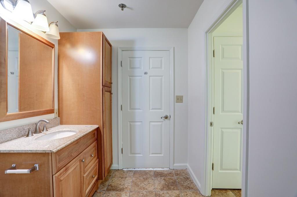 300 Johnson Ferry Road, Unit A405 Atlanta, GA 30328 - Photo 8 of 15 a bathroom with a granite countertop sink and a mirror