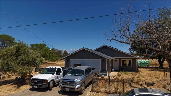 a front view of a house with cars parked
