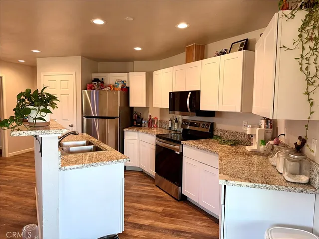 a kitchen with granite countertop a refrigerator stove and sink
