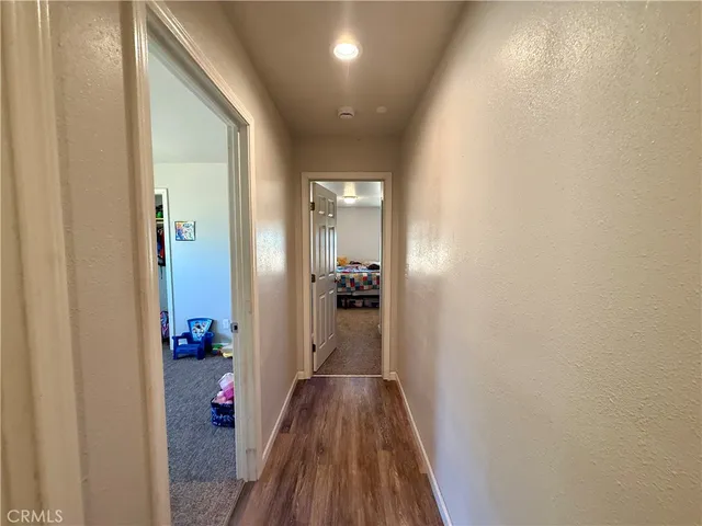 a view of a hallway with wooden floor and closet