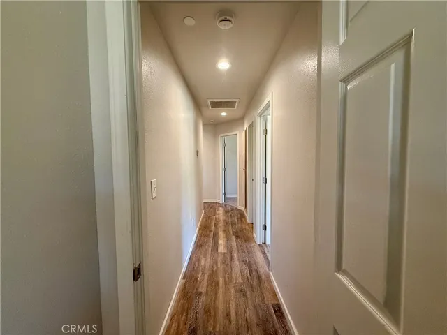 a view of a hallway with wooden floor and staircase