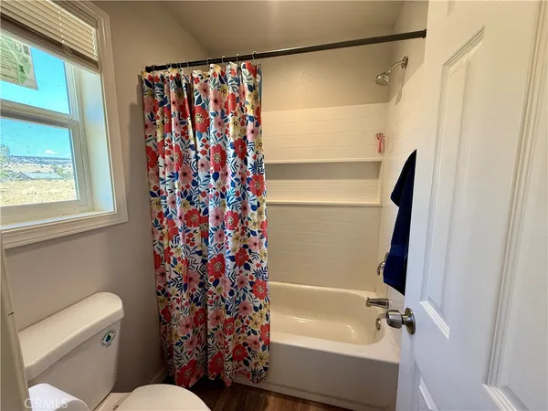 a bathroom with a shower curtain and a toilet