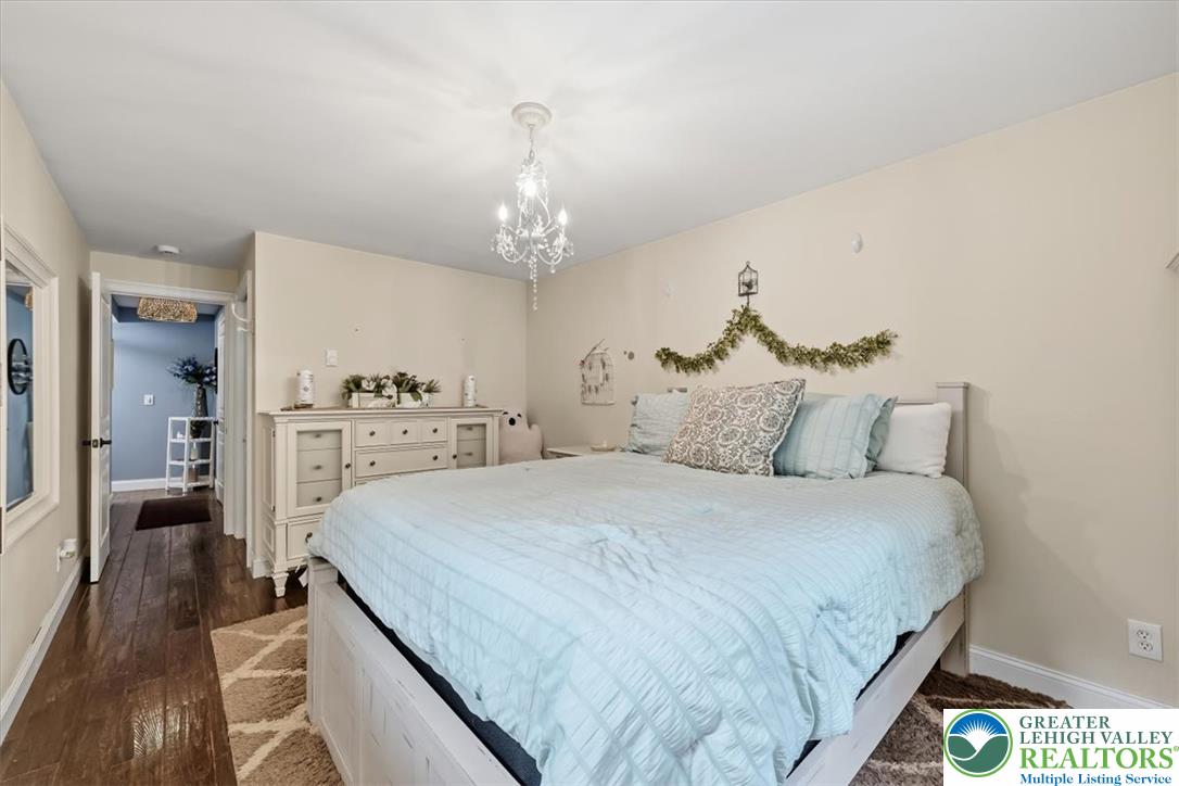 3771 State Road Coopersburg, PA 18036 - Photo 26 of 37 Rich hardwood flooring anchors this serene sleeping space illuminated by an elegant central chandelier.