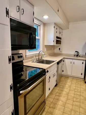 a kitchen with stainless steel appliances a stove microwave and sink