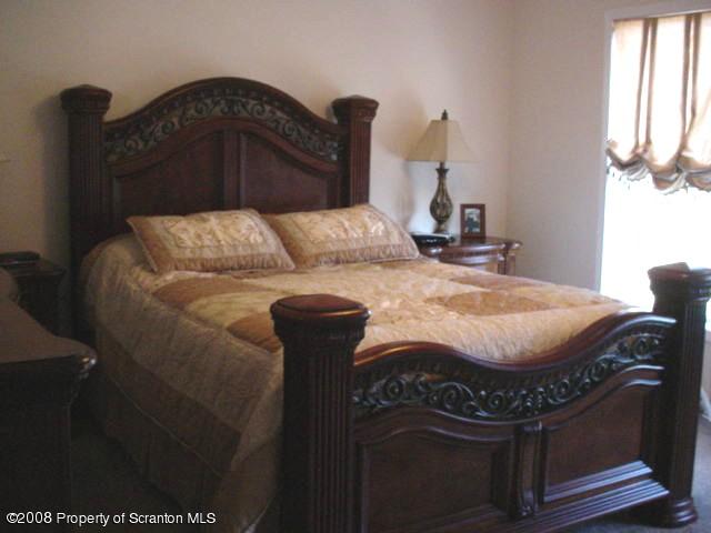2622 Boulder Road Lake Ariel, PA 18436 - Photo 7 of 9 a bed sitting in a bedroom next to a window with chair