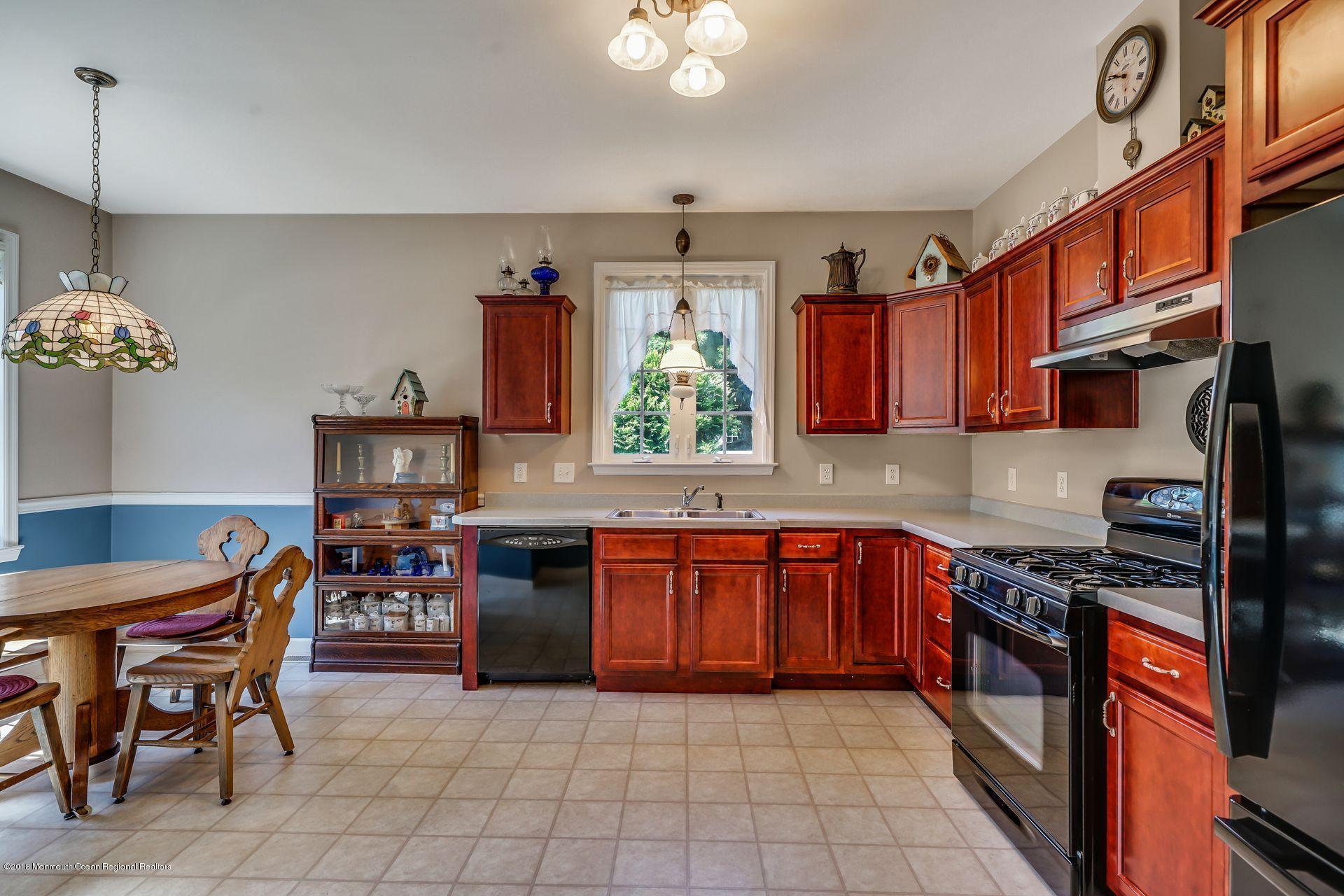 2569 Crestview Road Manasquan, NJ 08736 - Photo 16 of 35 a kitchen with stainless steel appliances granite countertop a stove top oven a sink dishwasher a dining table and chairs with wooden floor