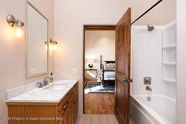 a bathroom with a granite countertop sink mirror bathtub and shower