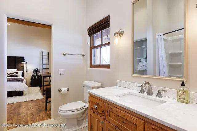 a bathroom with a granite countertop sink mirror vanity and toilet