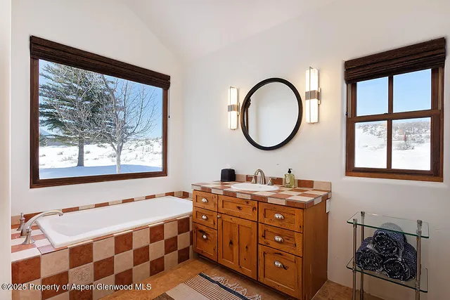 a bathroom with a double vanity sink a mirror and a window