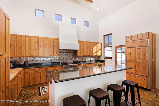 a kitchen with stainless steel appliances granite countertop a sink and a stove