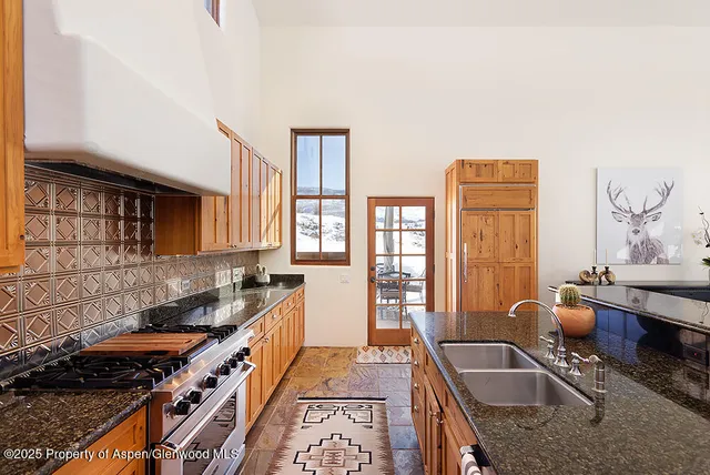 a kitchen with granite countertop a stove and a sink