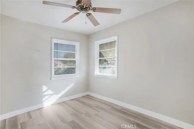 an empty room with windows and fan