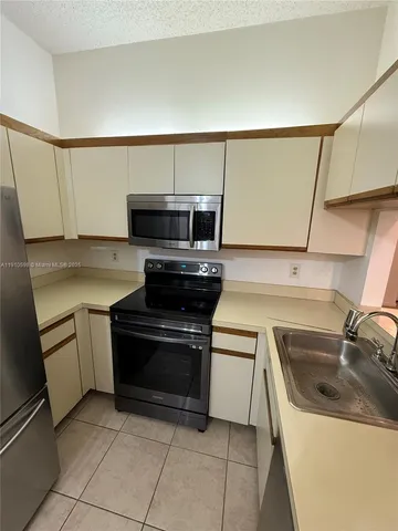 a kitchen with a sink and a stove top oven