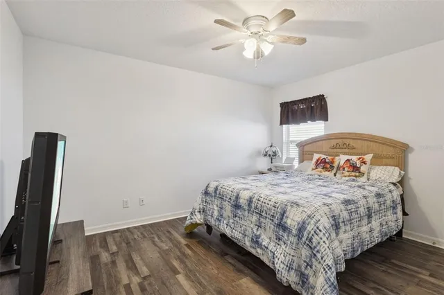 a bedroom with a bed and a ceiling fan