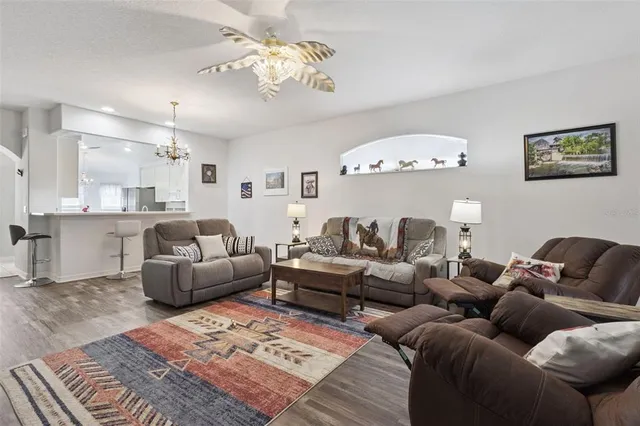 a living room with furniture chandelier and a rug