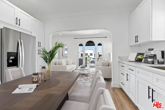 a living room with stainless steel appliances kitchen island furniture and wooden floor