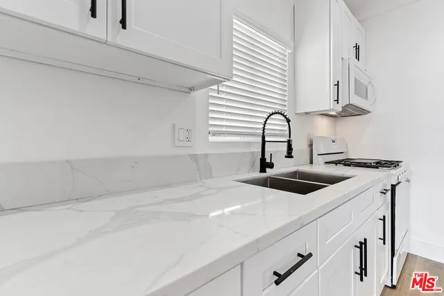 a kitchen with stainless steel appliances a sink and cabinets
