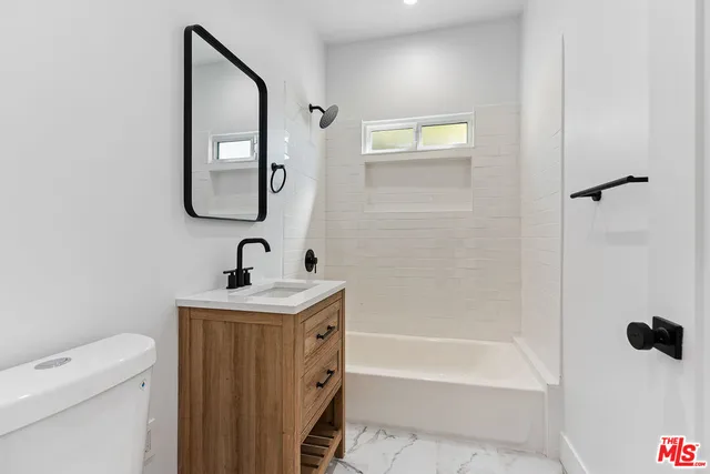 a bathroom with a sink a toilet and a mirror