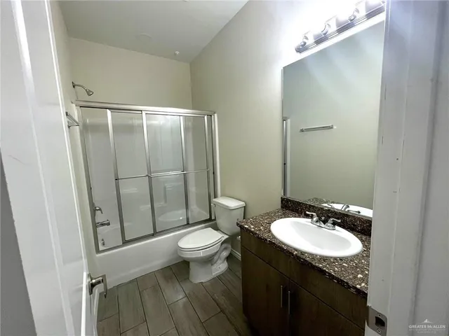 a bathroom with a granite countertop sink toilet and shower