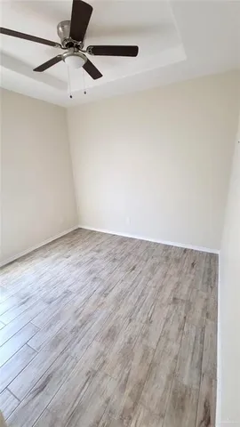 a view of a room with wooden floor and white walls