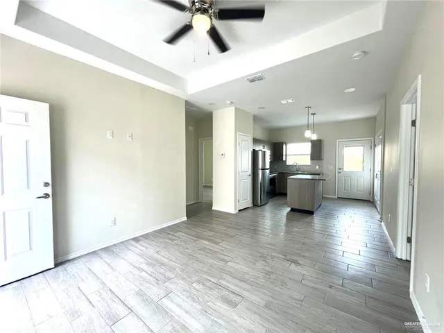 a view of a kitchen with a sink and a refrigerator