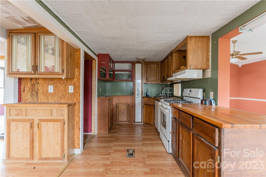 5 Cane Crest Circle Fairview, NC 28730 - Photo 10 of 13 a kitchen with stainless steel appliances granite countertop a refrigerator a sink dishwasher and wooden cabinets with wooden floor