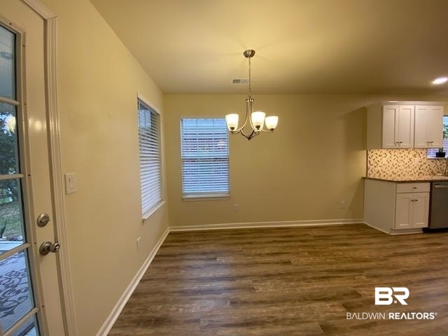 22713 Respite Lane Foley, AL 36535 - Photo 5 of 35 Unfurnished dining area featuring dark wood-type flooring and an inviting chandelier