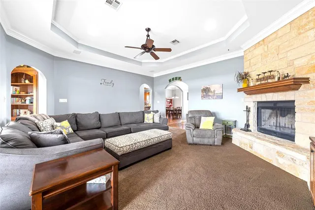 a living room with furniture a fireplace and a chandelier