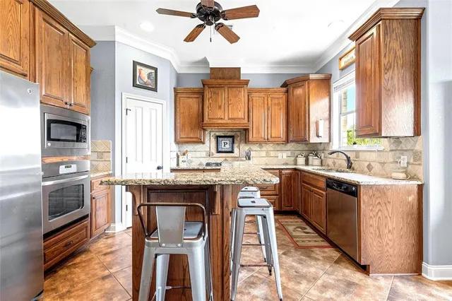 a kitchen with stainless steel appliances granite countertop a stove top oven a sink dishwasher a dining table and chairs with wooden floor