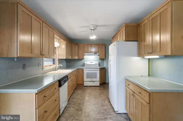 a kitchen with cabinets and white stainless steel appliances