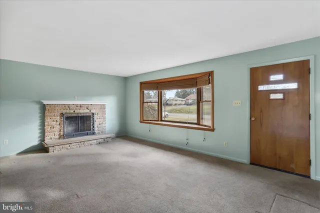 an empty room with windows and fireplace