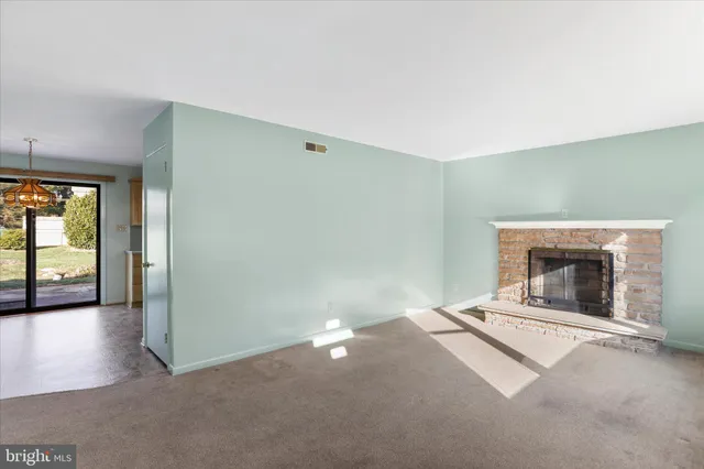 an empty room with a fireplace and windows