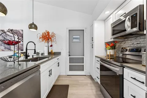 a kitchen with stainless steel appliances granite countertop a sink and stove top oven