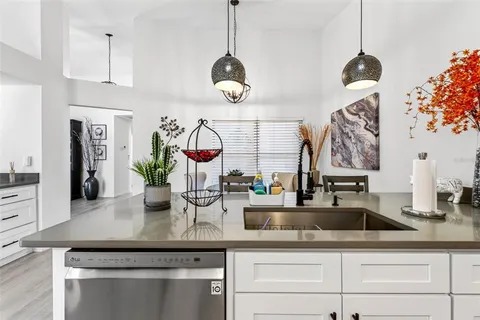 a kitchen with stainless steel appliances granite countertop a sink a counter space and cabinets