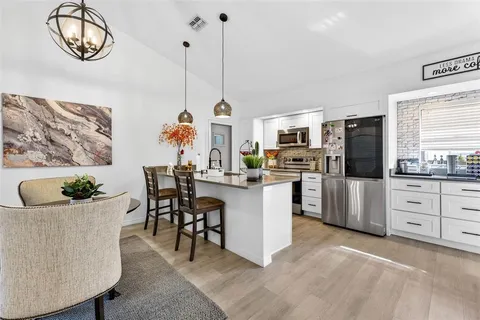 a kitchen with white cabinets and stainless steel appliances