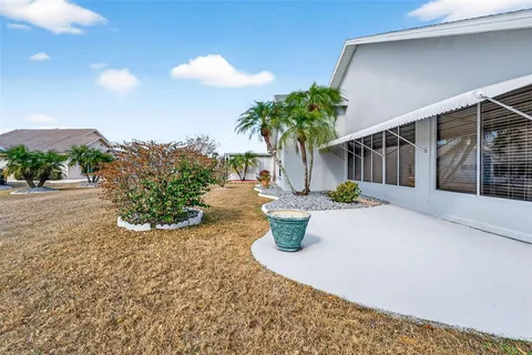 a view of a house with backyard and sitting area