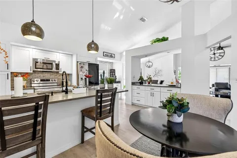 a dining room with furniture a chandelier and kitchen view