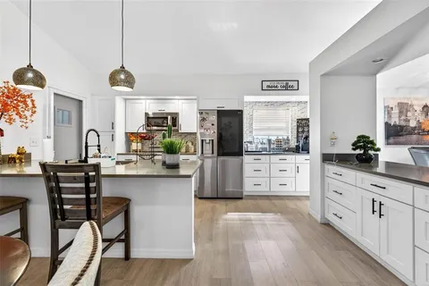 a kitchen with stainless steel appliances kitchen island granite countertop a stove a sink and a refrigerator