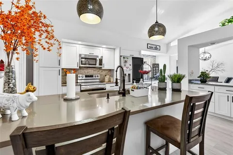 a kitchen with a table chairs and microwave