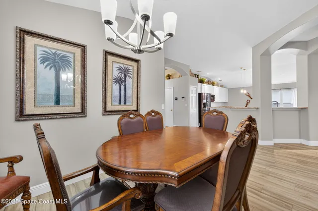 a view of a dining room with furniture wooden floor and chandelier