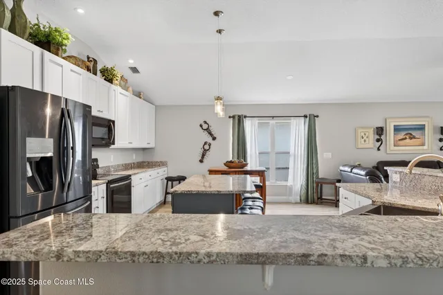 a kitchen with stainless steel appliances granite countertop a refrigerator stove microwave and sink