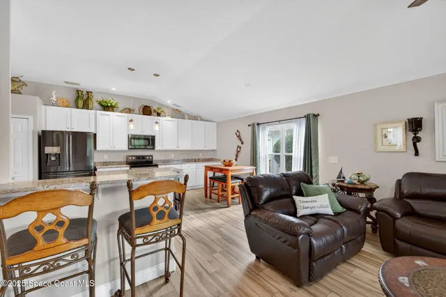 a living room with furniture and kitchen view