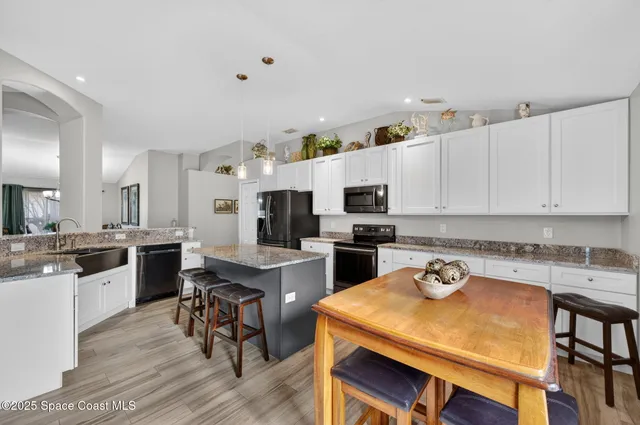 a kitchen with a dining table chairs and white cabinets