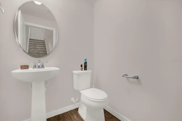 a bathroom with a toilet sink and mirror