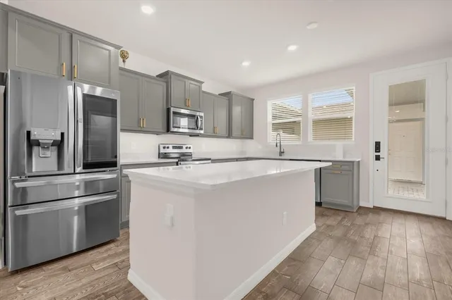 a kitchen with stainless steel appliances a refrigerator sink and cabinets
