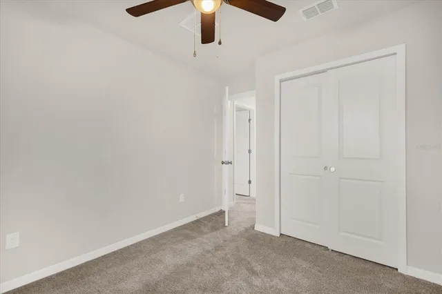 an empty room with chandelier fan